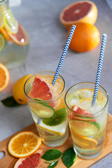 Health care, fitness, healthy nutrition diet concept. Fresh cool homemade citrus infused detox water with grapefruit, orange, lemon and lime and ice in a jug and glasses for spring summer days.