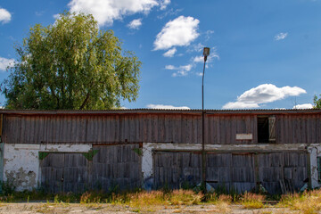 Large old brick workshop garage with wooden gates. Abandoned car workshop