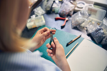 Caucasian female diligently working in jewelry studio
