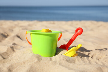 Fototapeta na wymiar Child plastic toys on sandy beach at sunny day
