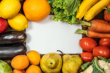 Healthy food vegan vegetarian background with vegetables and fruits on wooden table top view and white copy space in center as banner for your text.