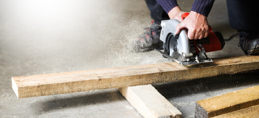 Carpenter builder working with circular saw. 