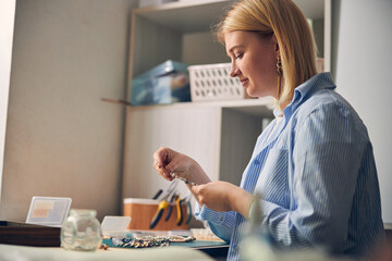 Obraz na płótnie Canvas Calm woman working on new bijouterie goods
