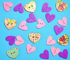 Romantic background with wooden multicoloured buttons in form of hearts against light-blue background. Concept for Saint Valentine's or romantic card.  Romantic wallpaper, love