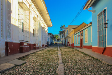 Empty cobblestone street with colonial colorful houses in Trinidad, Cuba. Beautiful Caribbean cityscape. UNESCO site famous tourist destination. Travel holiday background.Calm morning walk in the city