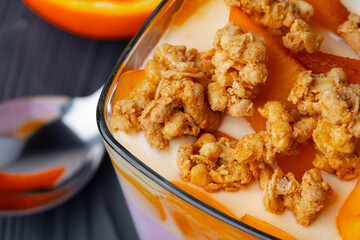 Tasty breakfast with granola, yoghurt and fruits in a glass bowl