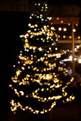 Fototapeta na wymiar Defocused lights on Christmas tree. Christmas atmosphere. 
