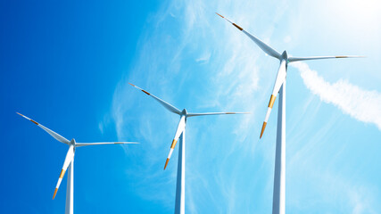 Wind power background - Blue cloudy sky with many windmill / wind turbines
