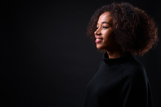 Young Beautiful African Woman With Afro Hair Against Black Background