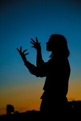 Femalе silhouette and sunset background