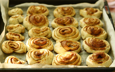 Obraz na płótnie Canvas cinnamon fresh baked sweet bun rolls dessert on tray