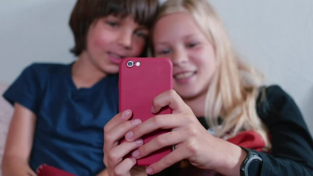 Close-up of the phone in the hands of children taking photos. Have fun at home in your free time. Sharing photos and emotions on social networks.