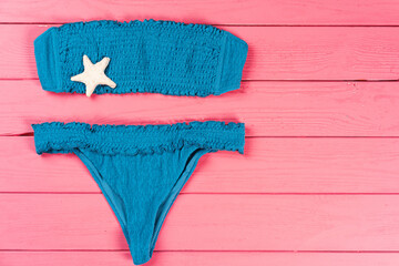 Blue bikini on bright pink wooden background