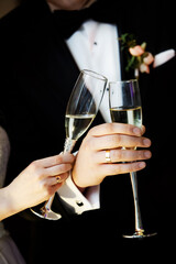hands of a newlywed couple with two glasses of champagne