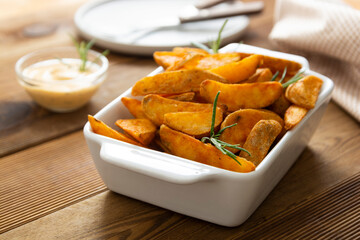 Fried potatos with herbs in white dish. Homemade roasted potatoes chips.