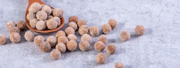 Dry raw brown tapioca pearls isolated on gray cement concrete background, close up, ingredient of making bubble boba tapioca milk tea.