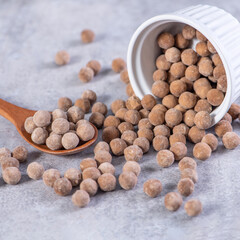 Dry raw brown tapioca pearls isolated on gray cement concrete background, close up, ingredient of making bubble boba tapioca milk tea.