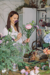 Beautiful female florist working in her flower shop arranging a birthday bouquet.