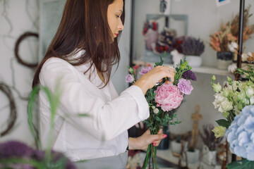 Florist arranging a bouquet in her flower shop . Small floral business owner. Female power startup concept.