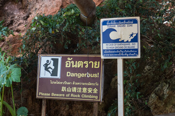 Warning signs about rock climbing and tsunami, at East Railay Beach, west of Krabi in southern...
