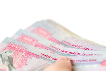 UAE dirhams in hand, banknotes of one hundred, closeup