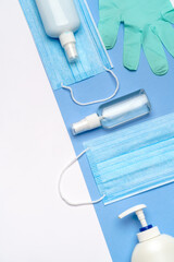 bottle of lotion, sanitizer or liquid soap, latex rubber gloves and medical protective mask isolated on light grey background