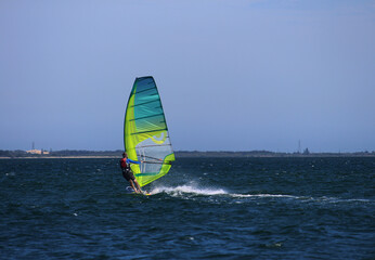 Man windsurfing across the ocean - sail boarding. Sydney