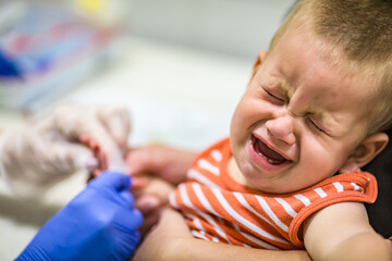 Baby health care and treatment. Medical research. Blood tests.Coronavirus COVID-19 quick Rapid Diagnostic Test RDT,medical worker place collected patient finger prick blood sample.