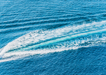 Trail on water surface behind of fast moving motor boat