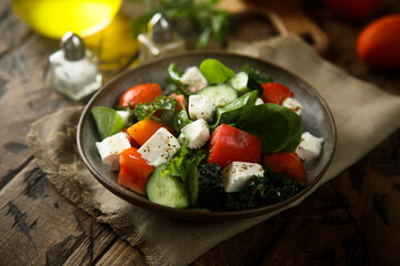 Traditional Greek salad with fresh spinach