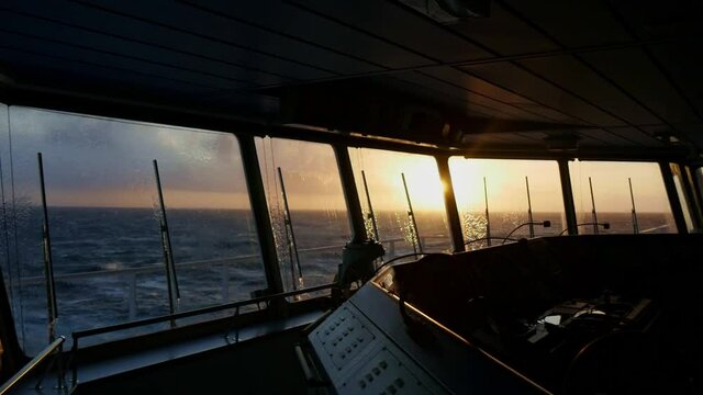 washing windows on the navigation bridge at sunset.