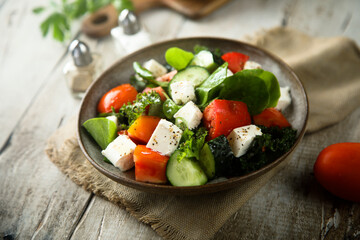 Traditional Greek salad with fresh spinach