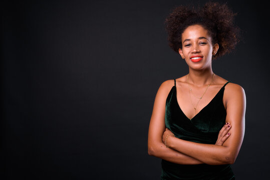 Young beautiful African woman with Afro hair against black background