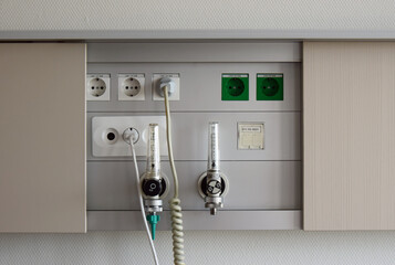 Anschlüsse für Sauerstoff, Druckluft und Strom an einem Krankenhausbett