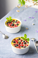 Delicious clafoutis made from white yogurt and berries, raspberries and blueberries, clafoutis in portioned bowls on the table