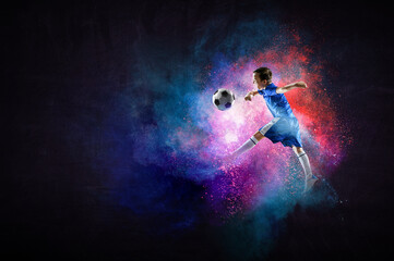 Boy playing soccer hitting the ball