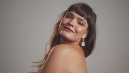Fototapeta premium Plus size fashion model posing topless isolated on grey background