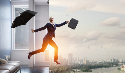 Young businesswoman walking with umbrella