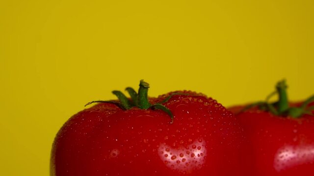 Red tomatoes on yellow background. Place for text.