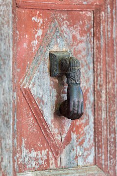 heurtoir de porte d'entr&eacute;e en forme de main tenant une boule