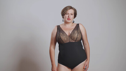 Young beautiful plus size model with stylish haircut and makeup in underwear