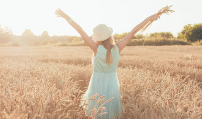 A young girl in a hat runs across the field