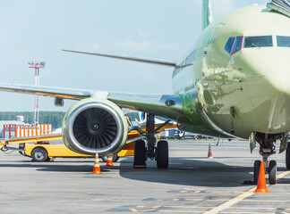 Airplane parked at the airport before departure, loading baggage.