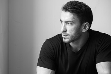 Portrait of handsome bearded man by the window indoors