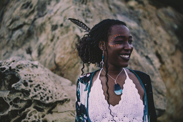A trendy and attractive young black woman in a dress in a shore background in summer.  © Dellealpi