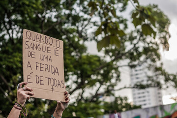 Mãos femininas segurando cartaz em protesto de mulheres. Manifestação contra violência contra...