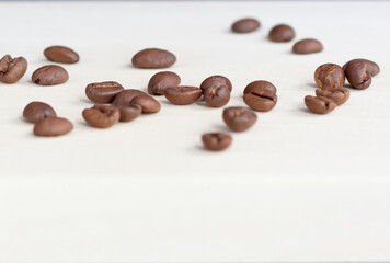 Naklejka premium Roasted coffee beans on a wooden background. Coffee and light wood background. Seeds.