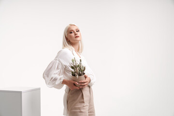 Portrait of female model posing with cactus.