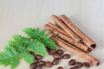 Cinnamon sticks and coffee beans. Roasted coffee beans on a wooden background. Light tree background.