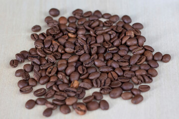 Roasted coffee beans on a wooden background. Coffee and light wood background. Seeds.